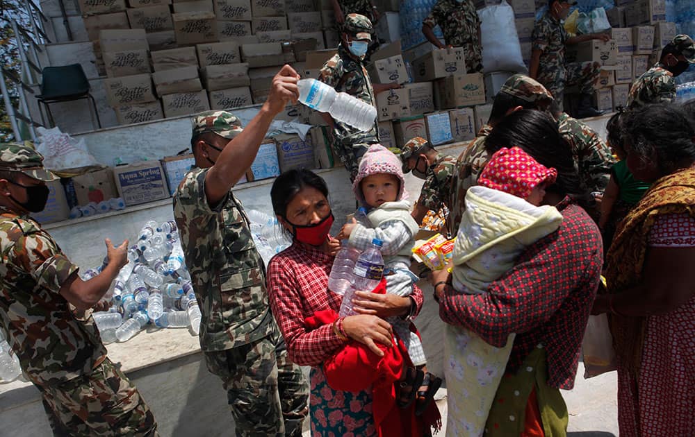 Nepalese army distribute drinking water and packed noodles for people who have had their homes damaged and living in tents during the April 25 earthquake in Kathmandu, Nepal.