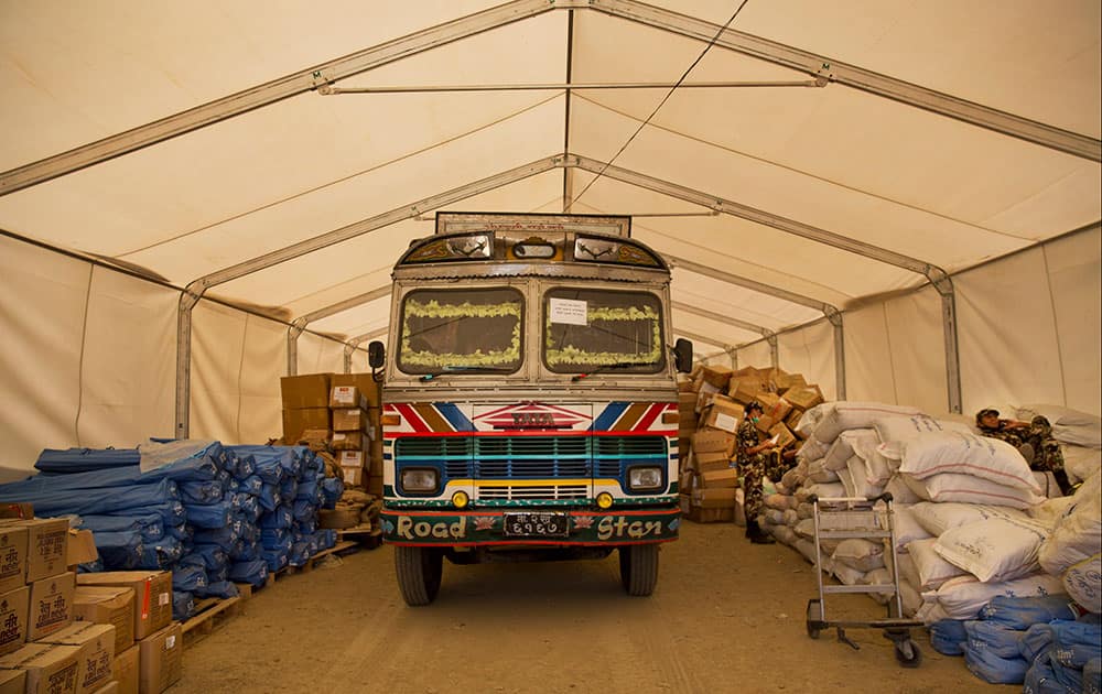 A Nepalese truck is surrounded by miscellaneous aid supplies at the cargo terminal of Tribhuvan International airport in Kathmandu, Nepal