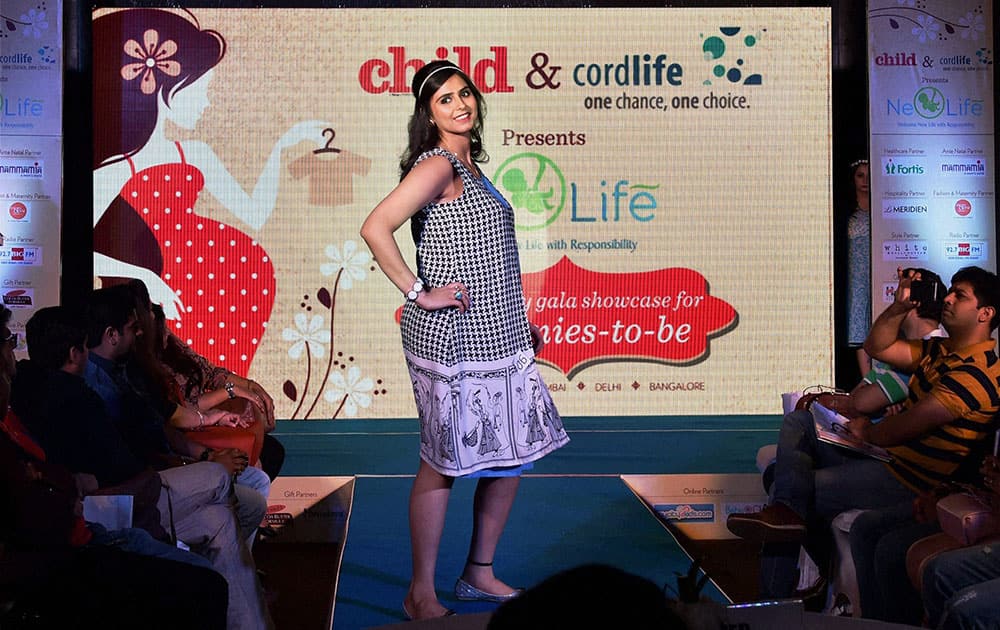 A pregnant mother walks the ramp during an event that celebrates motherhood, in New Delhi.