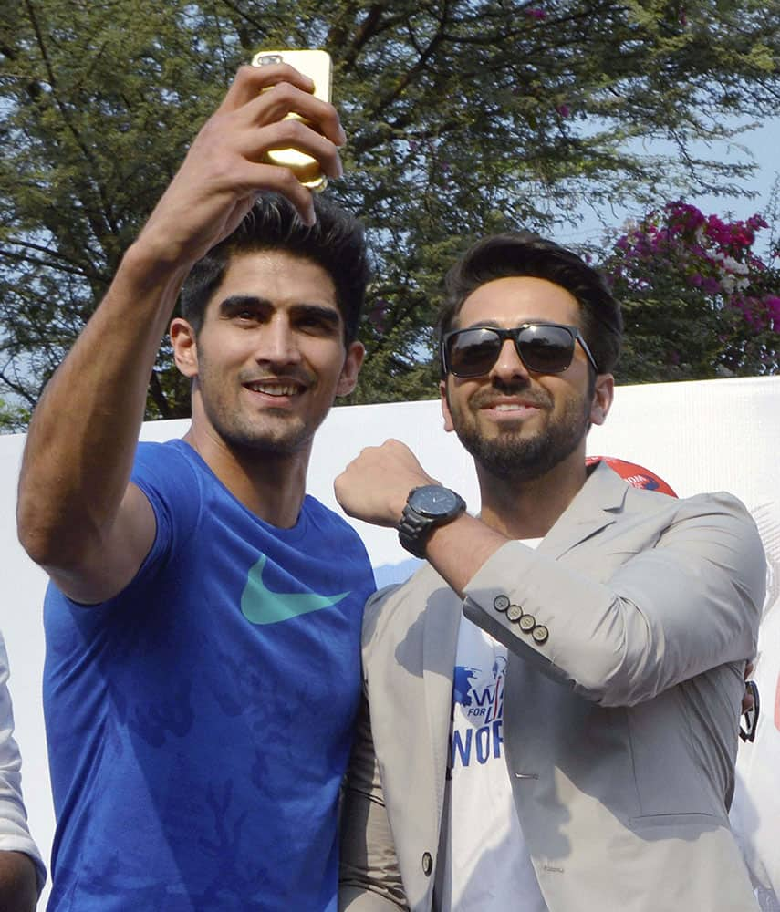 Bollywood actor Ayushman Khurana and boxer Vijender Singh pose during Wings for life world run in Gurgaon.
