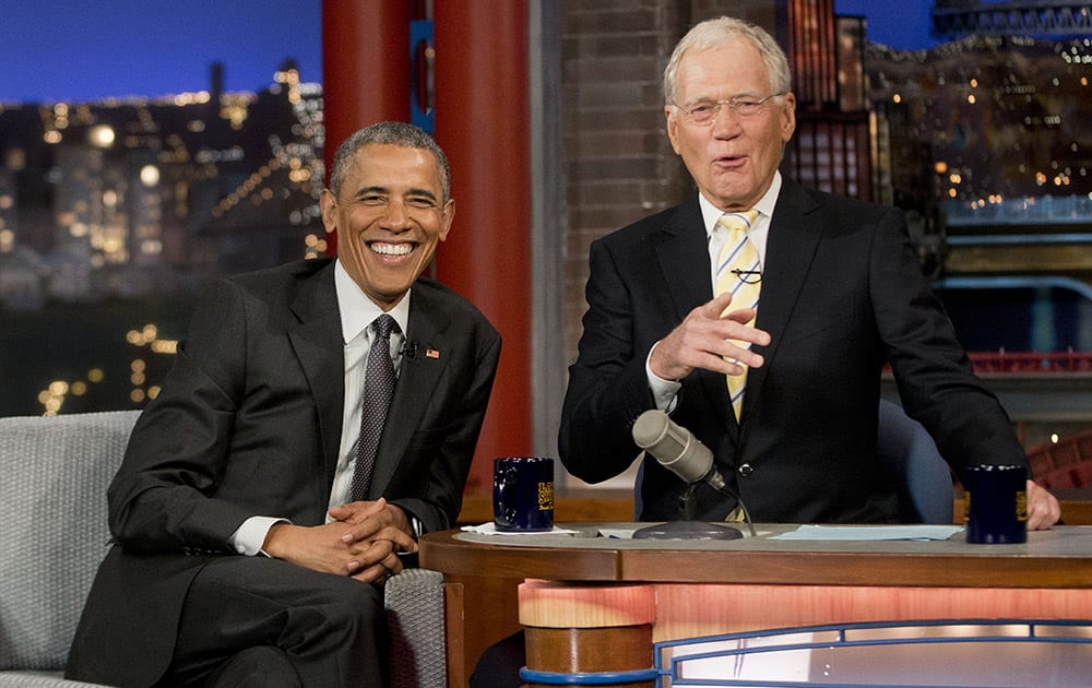 President Barack Obama with host David Letterman talk during a break at a taping of CBS' The Late Show with David Letterman at the Ed Sullivan Theater in New York.