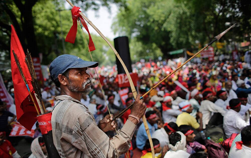A farmer holds a bow and an arrow as he attends a gathering near the Indian parliament for a protest against the Land Acquisition Bill, in New Delhi.