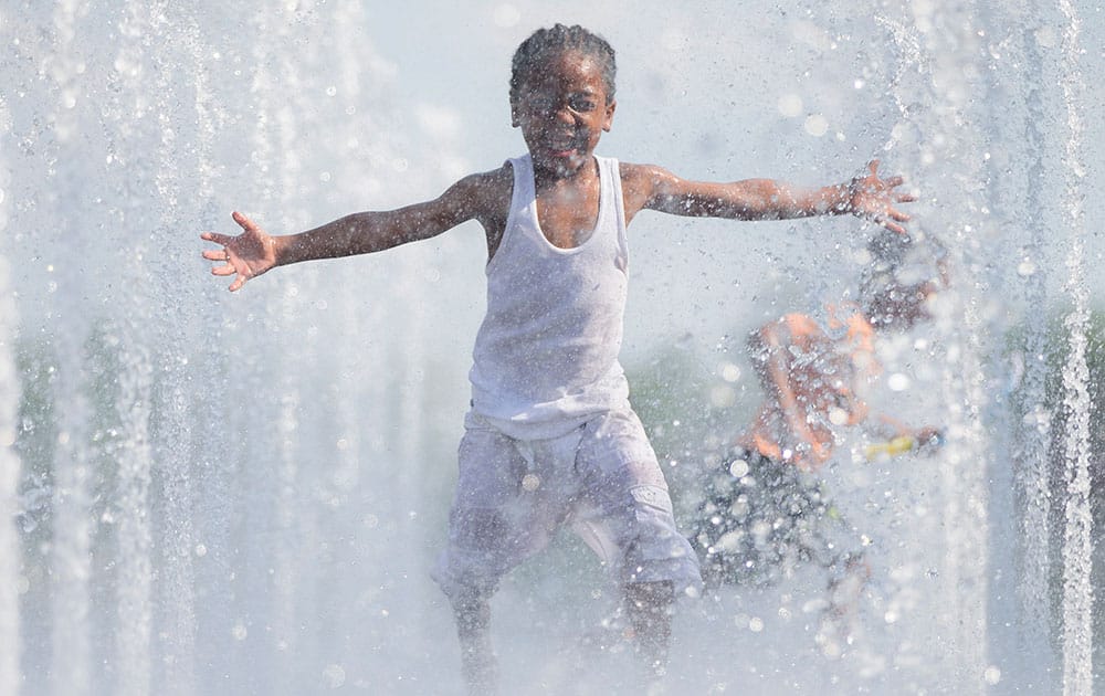 Kaydann Marshall runs through a park fountain in Cincinnati. Temperatures rose past 80 degrees for the second consecutive day as warmer weather settled into the region. 