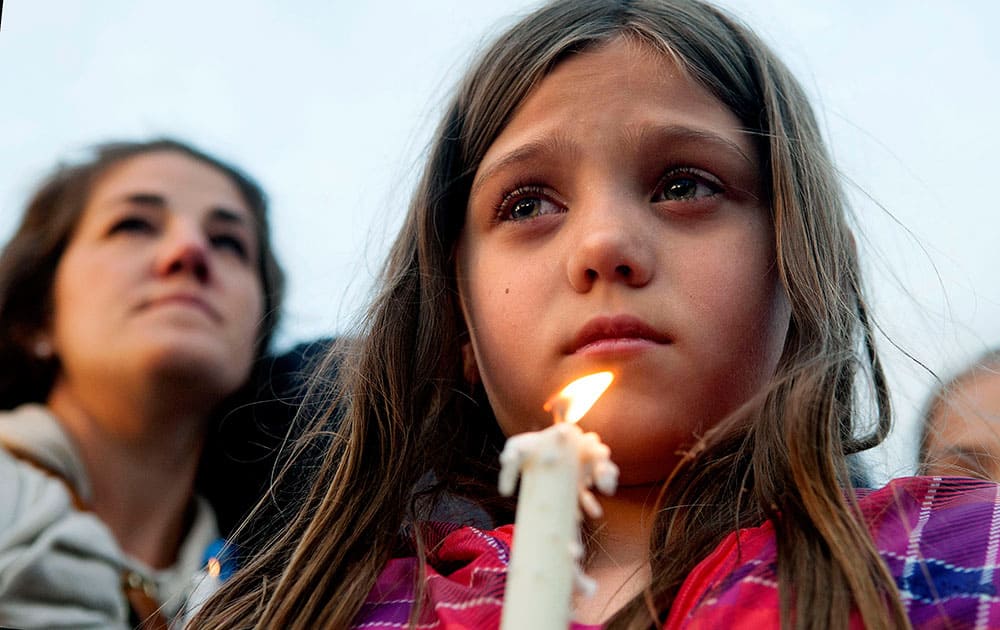 Maya Averill, 9, attends a candlelight vigil for Sgt. Greg Moore, a 16-year veteran of the Coeur d'Alene Police Department who was shot after checking on a suspicious person in a neighborhood, in northwest Coeur d'Alene, Idaho.
