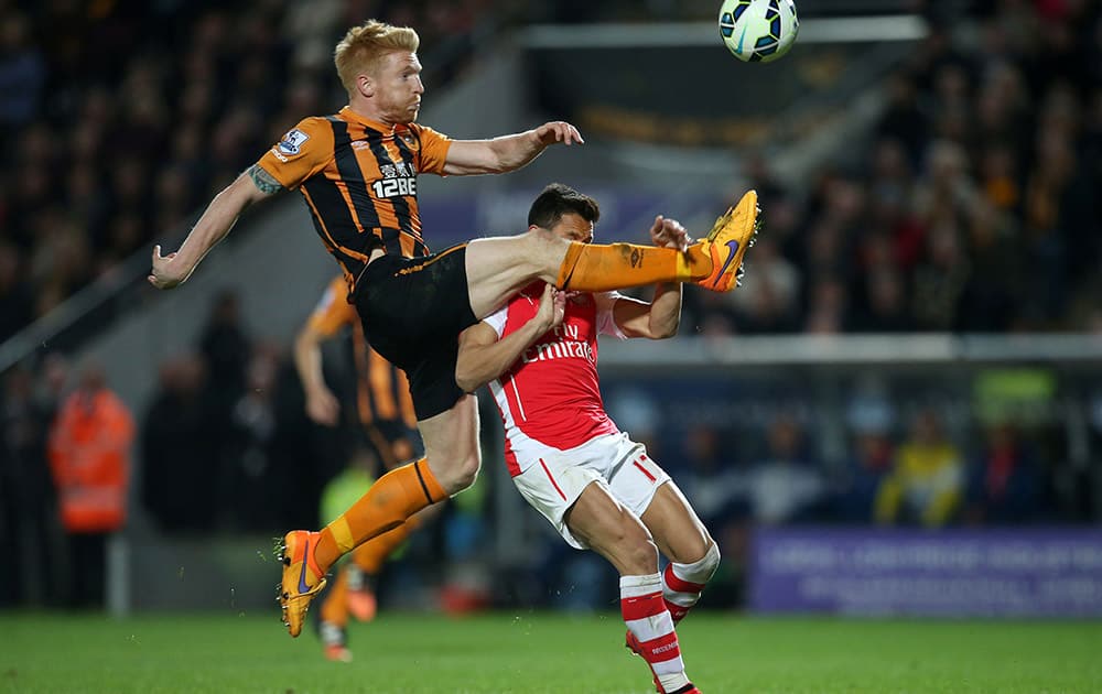 Hull City's Paul McShane, left, battles for the ball with Arsenal's Alexis Sanchez during the English Premier League soccer match at the KC Stadium, Hull, England.