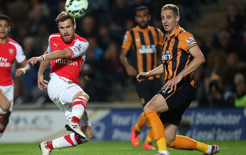 Arsenal's Aaron Ramsey, left, and Hull City's Michael Dawson during the English Premier League soccer match at the KC Stadium, Hull, England.