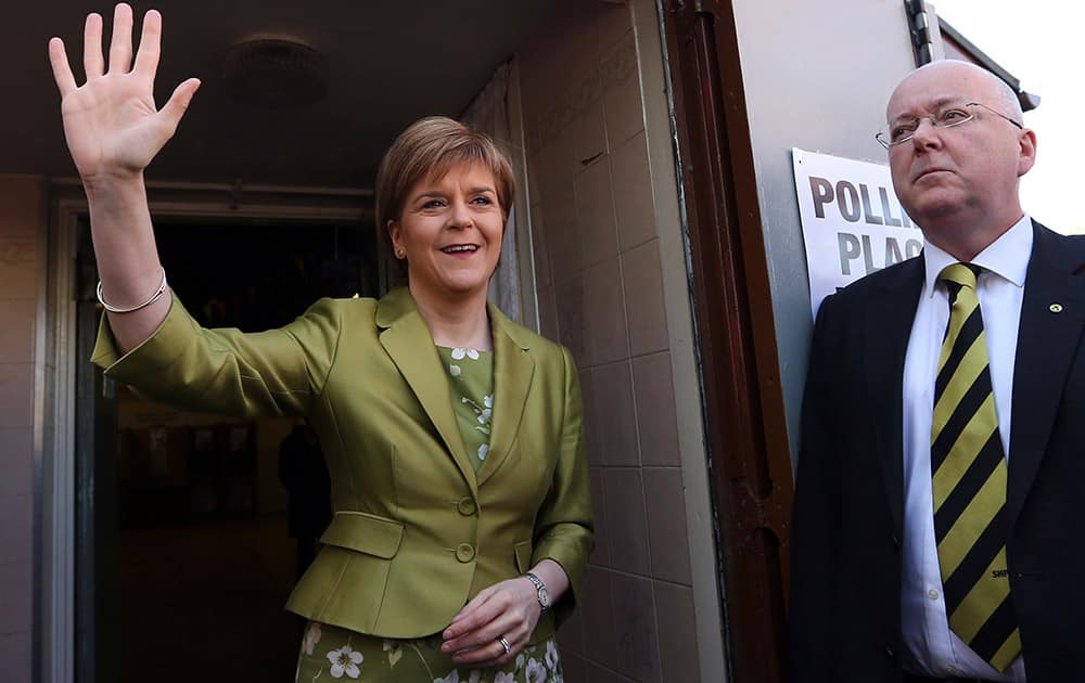 First Minister of Scotland and Scottish National Party leader Nicola Sturgeon and her husband Peter Murrell pose for photographs after casting her ballot at Broomhouse Community Hall in Broomhouse, Scotland.