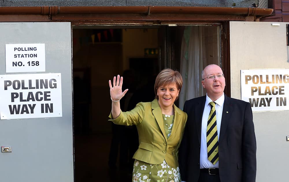 First Minister of Scotland and Scottish National Party leader Nicola Sturgeon and her husband Peter Murrell pose for photographs after casting her ballot at Broomhouse Community Hall in Broomhouse, Scotland.