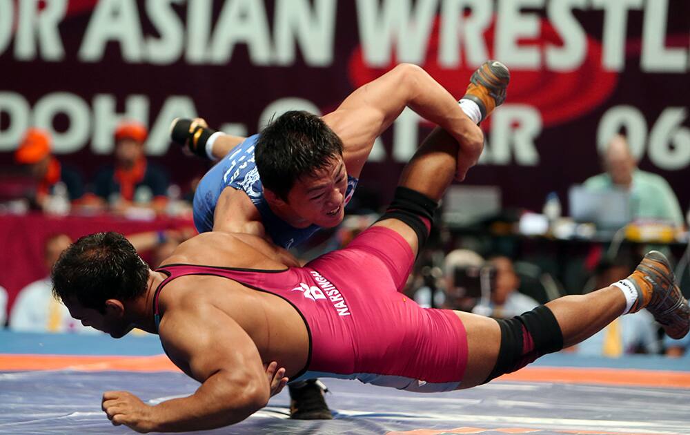 Japanese wrestler Daisuke Shimada, wrestles Indian wrestler Narsingh Pancham during the quarter final round of the 74 kilogram freestyle at the Asian Wrestling Championships in Doha, Qatar.