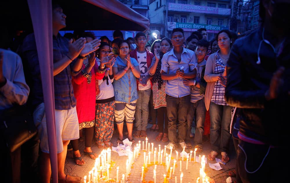 Nepalese people pay tributes to the victims of the April 25 earthquake, as they light candles near the destroyed landmark Dharahara tower in Kathmandu.