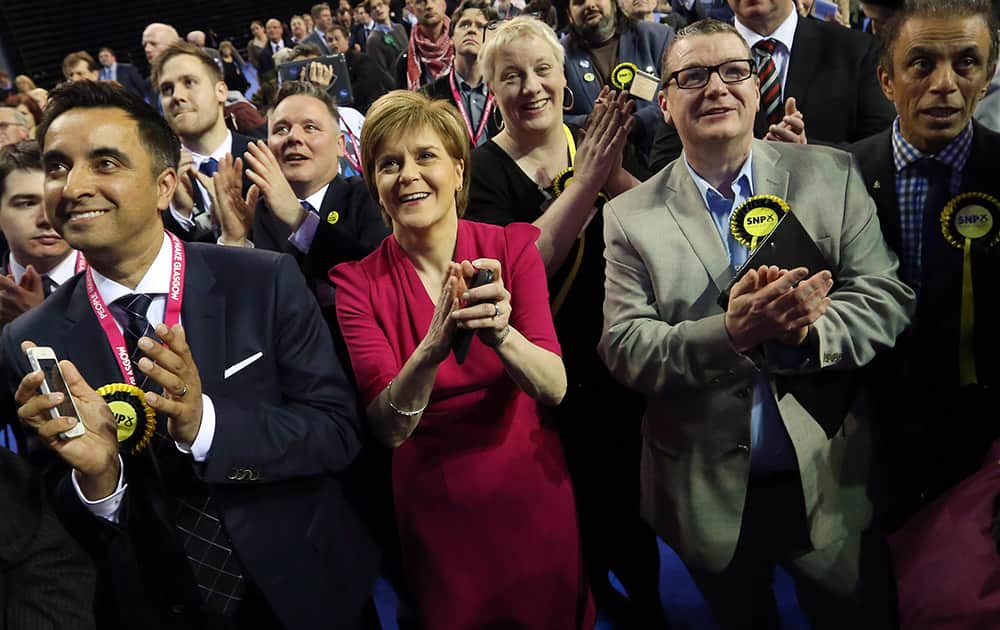 First Minister of Scotland and Scottish National Party leader Nicola Sturgeon, center, celebrates with the results for her party at the count of Glasgow constituencies for the general election in Glasgow, Scotland