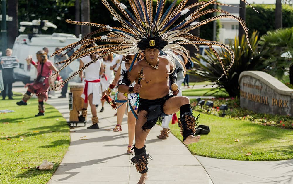 Aztec dancers join Los Angeles community members to demand that Hillary Rodham Clinton oppose the Trans-Pacific Partnership (TPP) and Trade Promotion Authority (TPA) known as 'The Fast Track,' in Beverly Hills, Calif.