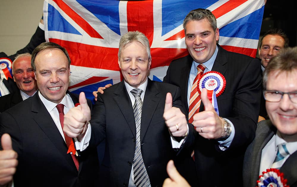 Democratic Unionist Party leader Peter Robinson, center, celebrates with his general election candidates Nigel Dodds, left, Gavin Robinson, 2nd right, and Jeffrey Donaldson, front right, after they were elected as MPs at the Kings Hall count center in Belfast, Northern Ireland.