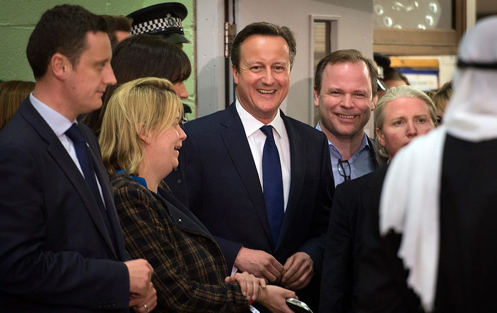 Britain's Conservative party leader David Cameron smiles as he talks to party officials and workers before receiving results at his Witney constituency count in Witney, England. Cameron's Conservative Party fared much better than expected in parliamentary elections Thursday, an exit poll projected, suggesting it is within touching distance of forming a new government.