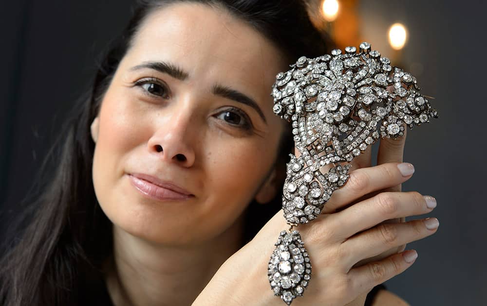 A Christie's employee holds the Maria Christina Royal 'Devant-de Corsage' diamond, mounted in silver and gold, broach, which is estimated to sell between 9,500,000 to 12,500,000 US dollar, during a preview at Auction house Christie's, in Geneva, Switzerland.