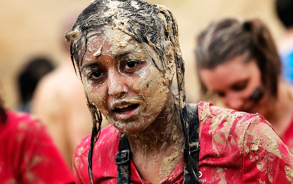 A participant of the Mud Day athletic event looks on, among the mud obstacles in Beynes, west of Paris, France.