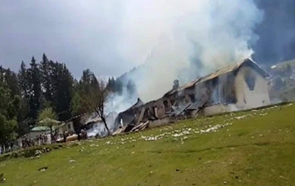 This still image taken from video shows smoke rising from an empty burning building, belonging to an army school, where a Pakistani army helicopter crashed in Nalter Valley, Gilgit, Pakistan