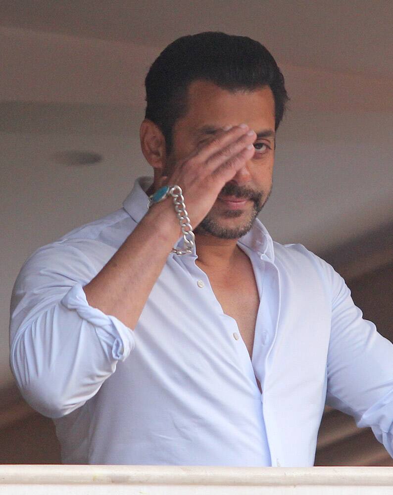 Salman Khan greets fans from the balcony of his residence in Mumbai.