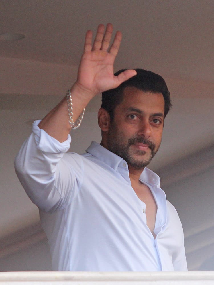 Salman Khan greets fans from the balcony of his residence in Mumbai.