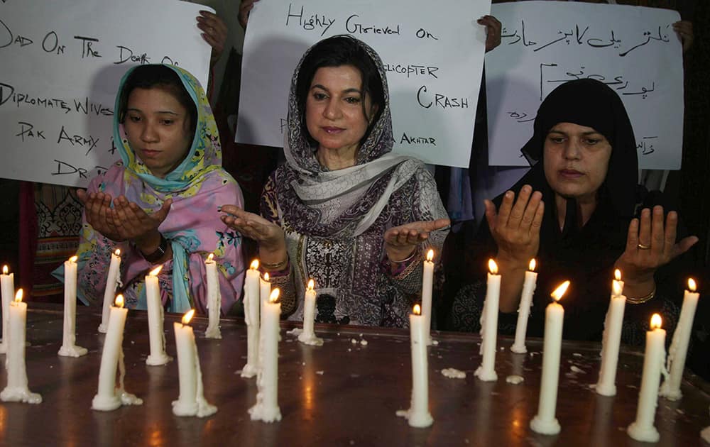 Pakistanis light candles and offer prayers for the victims of a helicopter crash, in Multan, Pakistan