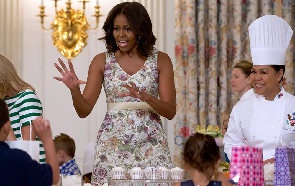 First lady Michelle Obama visits with children as they make gifts for their mothers during the annual Mother’s Day Tea to honor military-connected mothers at the White House in Washington.