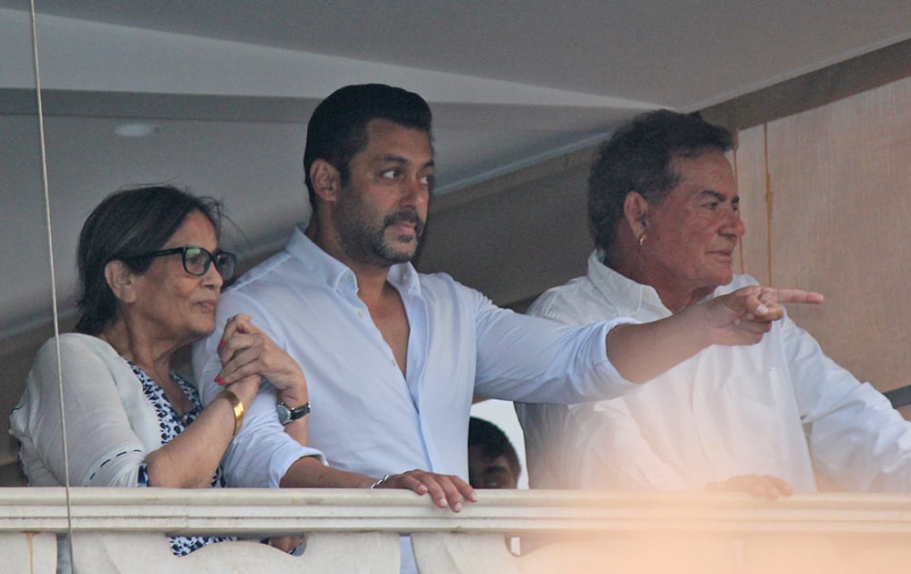 Bollywood actor Salman Khan gestures to fans from the balcony of his home, flanked by his mother Sushila Charak and father Salim Khan in Mumbai.