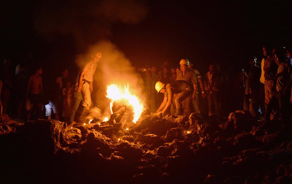 Fire workers at work after a MiG-27 fighter jet crashed at a village.