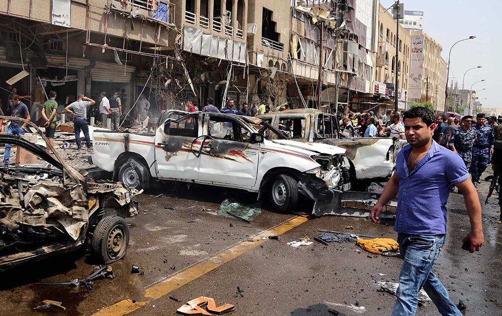 Civilians and security forces inspect the scene of a car bomb explosion in Karrada neighborhood, Baghdad, Iraq. A car bomb exploded in Baghdad's central Karrada area, killing at least eight civilians and wounding dozens, a police officer said. 