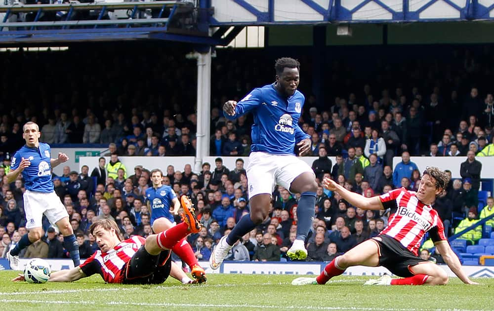 Sunderland's Sebastian Coates, left, and teammate Billy Jones, right, battle for the ball with Everton's Romelu Lukaku, centre, during the English Premier League match between Everton and Sunderland, at Goodison Park, in Liverpool, England.