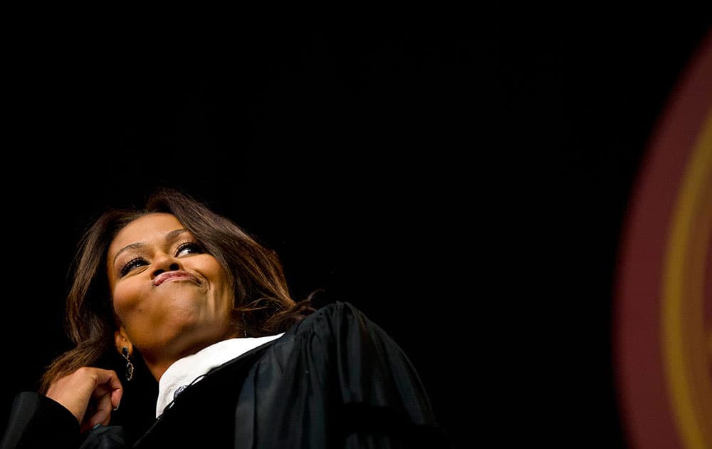 First lady Michelle Obama flips her hair after telling the graduates that they all look amazing just before delivering the commencement address at Tuskegee University, in Tuskegee, Ala.