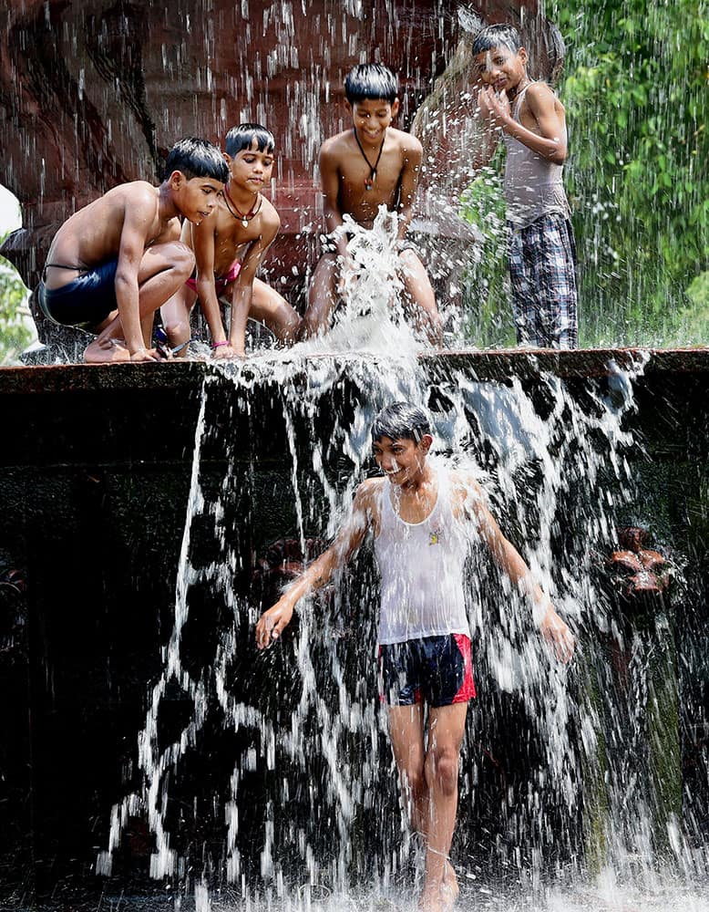 Children enjoy in the waters at the India Gate Boat Club as the mercury rises in New Delhi.