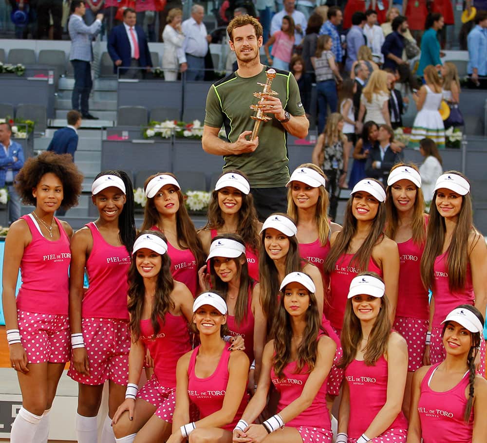 Andy Murray of Britain poses with the ball girls and his trophy at the end of the Madrid Open Tennis tournament.