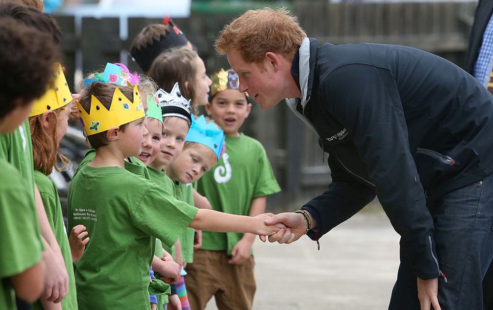 Britain's Prince Harry smiles as he shakes hands with a student while visiting Halfmoon Bay school on Stewart Island, New Zealand.