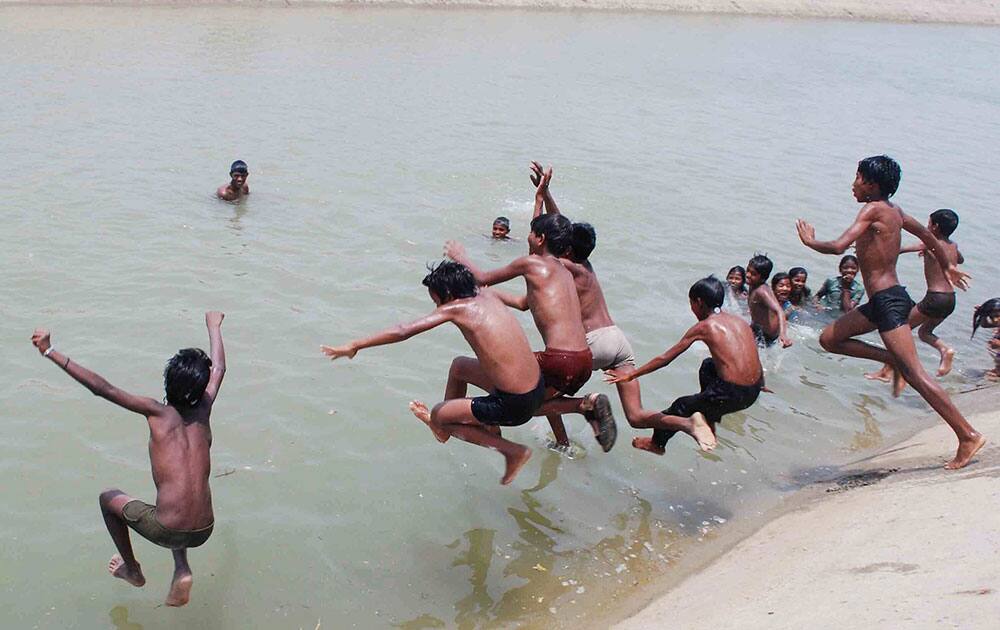 Children enjoy bathing in the River Ganges on a hot day in Allahabad.