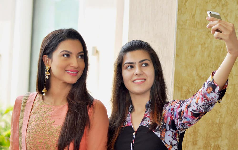 A fan takes a selfie with actress Gauhar Khan at an event in Patiala.
