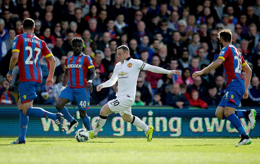 Manchester United's Wayne Rooney, competes for the ball with Crystal Palace’s Damien Delaney, left, Pape Souare, second left, and Joe Ledley during the English Premier League soccer match between Crystal Palace and Manchester United at Selhurst Park stadium in London.