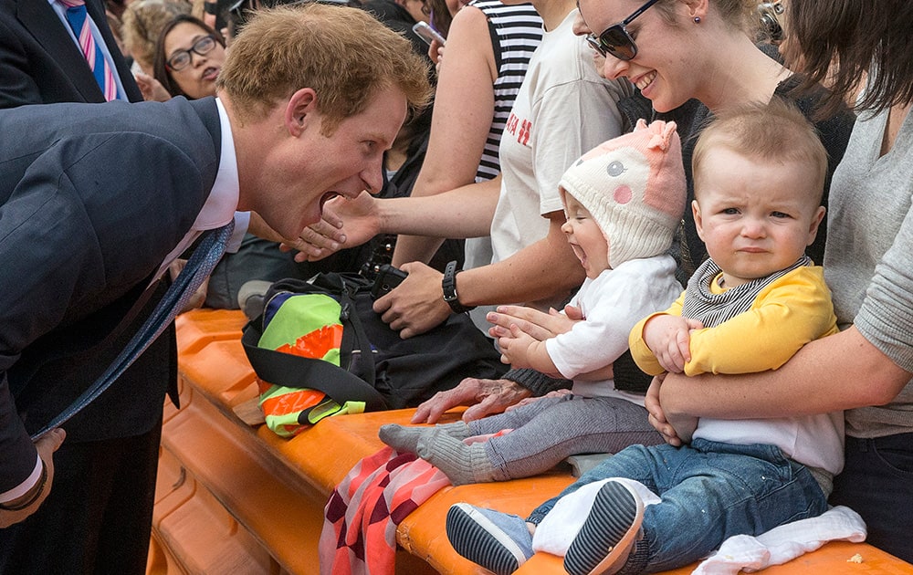 Britain's Prince Harry, mimics a baby as he meets people at a mall in Christchurch, New Zealand. Harry has admitted that watching his brother Prince William's family grow is making him wish he had a family of his own.