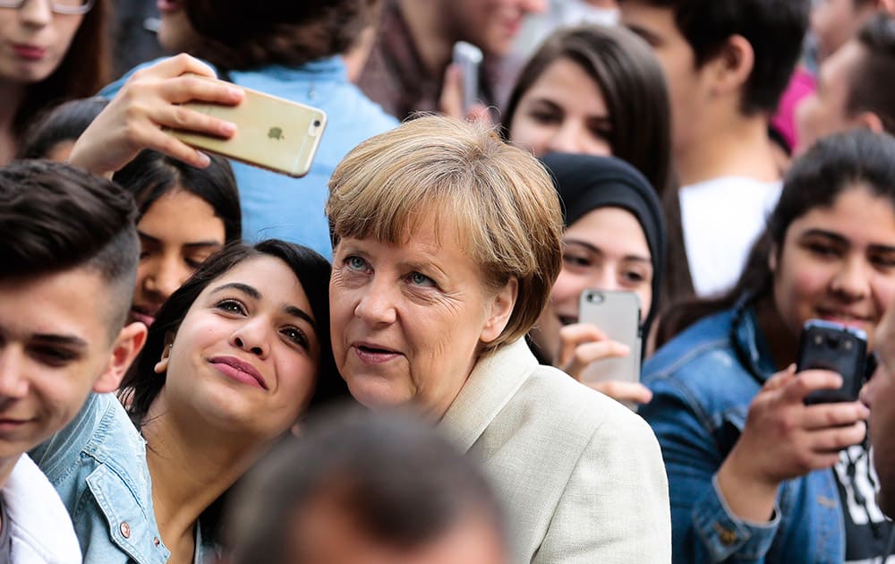 A student of the Roentgen School takes a selfie with German Chancellor Angela Merkel, as the Chancellor arrives for a visit at the secondary school in Berlin, Germany.