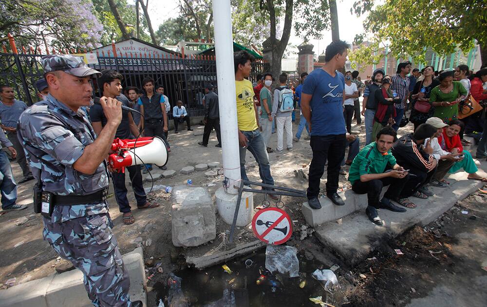 A policeman uses a loudspeaker to direct the public to safer areas after an earthquake hit Kathmandu, Nepal.