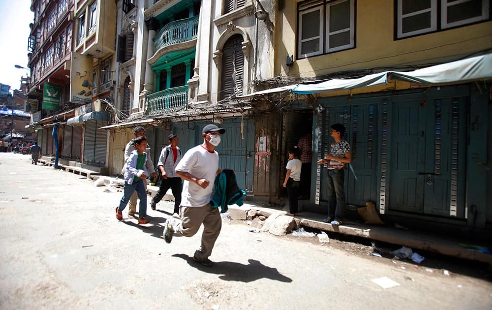 A Nepalese man runs to safety after a second earthquake hit Nepal in Kathmandu, Nepal.