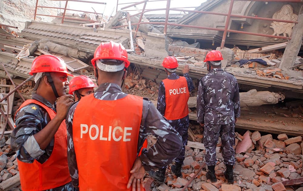 A Nepalese rescue team inspects the site of a building that collapsed in an earthquake in Kathmandu, Nepal.