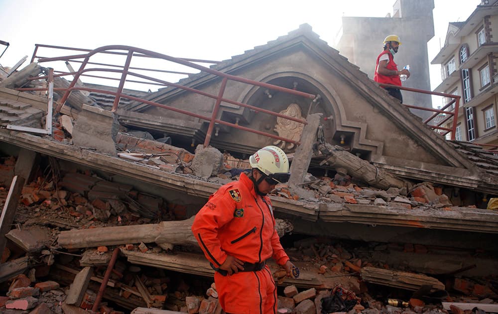 A Mexican rescue worker stands at the site of a building that collapsed in an earthquake in Kathmandu, Nepal.