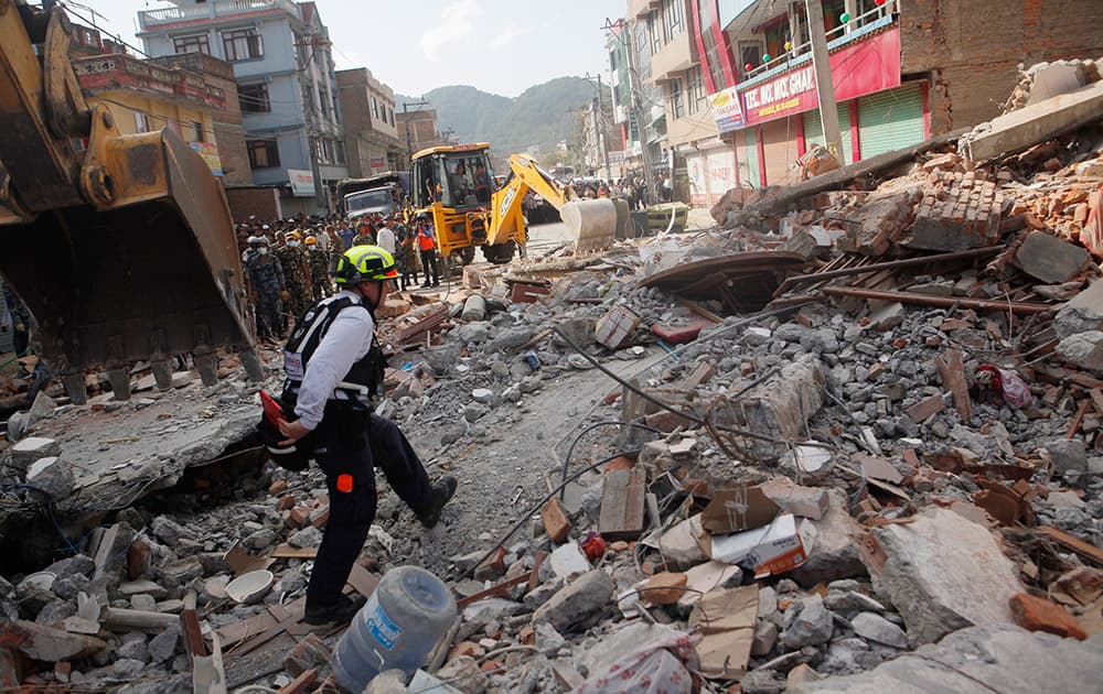 A rescue worker from USAID inspects the site of a building that collapsed in an earthquake in Kathmandu, Nepal.