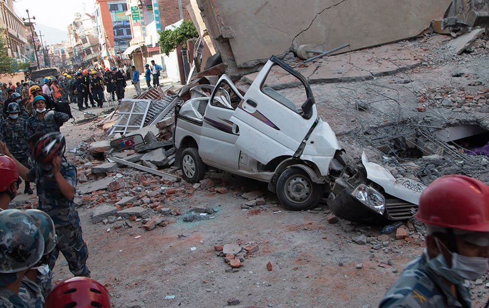 A car is seen smashed under the weight of a building that collapsed in an earthquake in Kathmandu, Nepal.