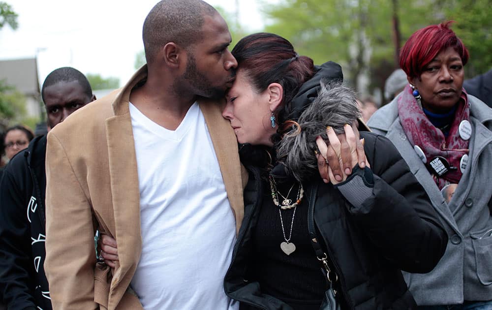 Jeff Jackson, left, comforts his girlfriend, Andrea Irwin, the mother of Tony Robinson, while escorting her during a protest march on Williamson Street, in Madison, Wis.