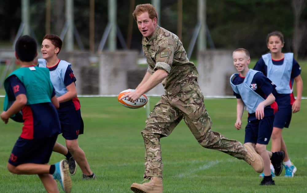 Britain's Prince Harry plays rugby with Linton Camp School children during a visit to the Linton Military Camp near Palmerston North, New Zealand.