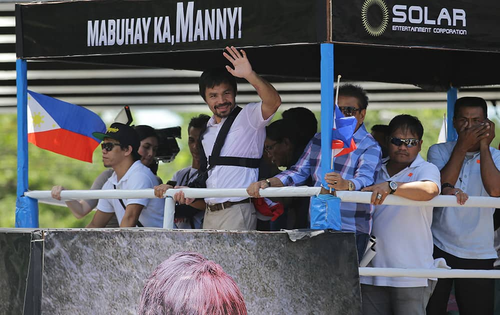 Filipino boxing hero Manny Pacquiao waves during a welcome parade as he arrives in Manila, Philippines. Pacquiao returned home to the Philippines on Wednesday nursing his right shoulder after surgery and weighing whether to retire or push for a rematch with Floyd Mayweather Jr. 