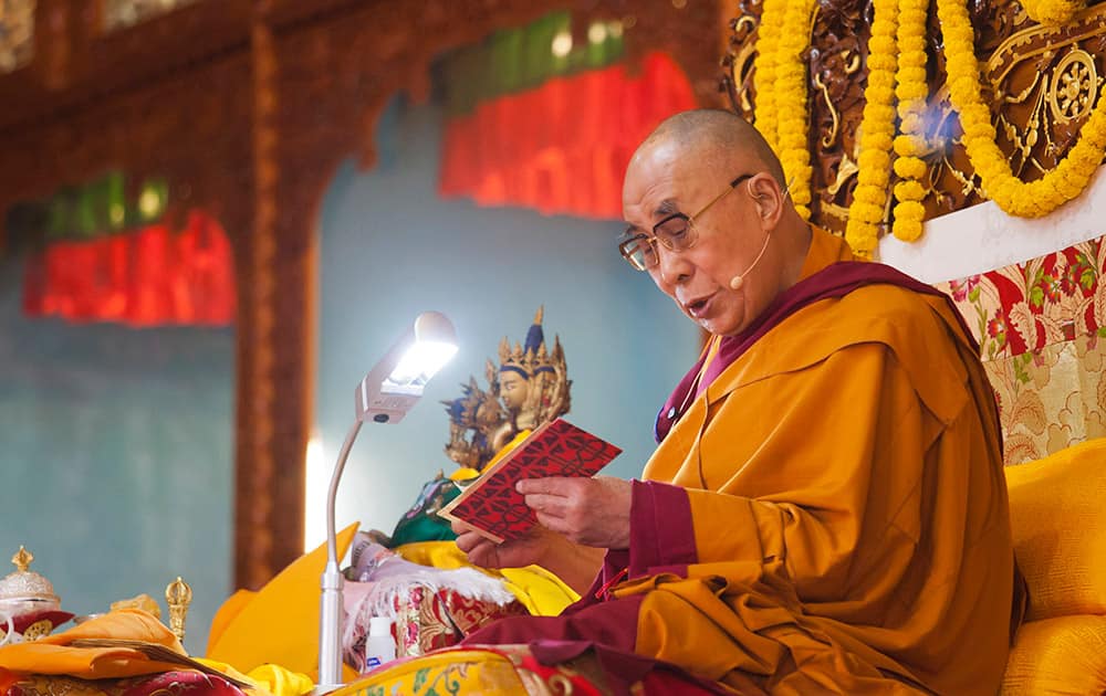 Tibetan spiritual leader the Dalai Lama reads from a Buddhist text during his religious talk at the Gyuto Monastery in Dharmsala.