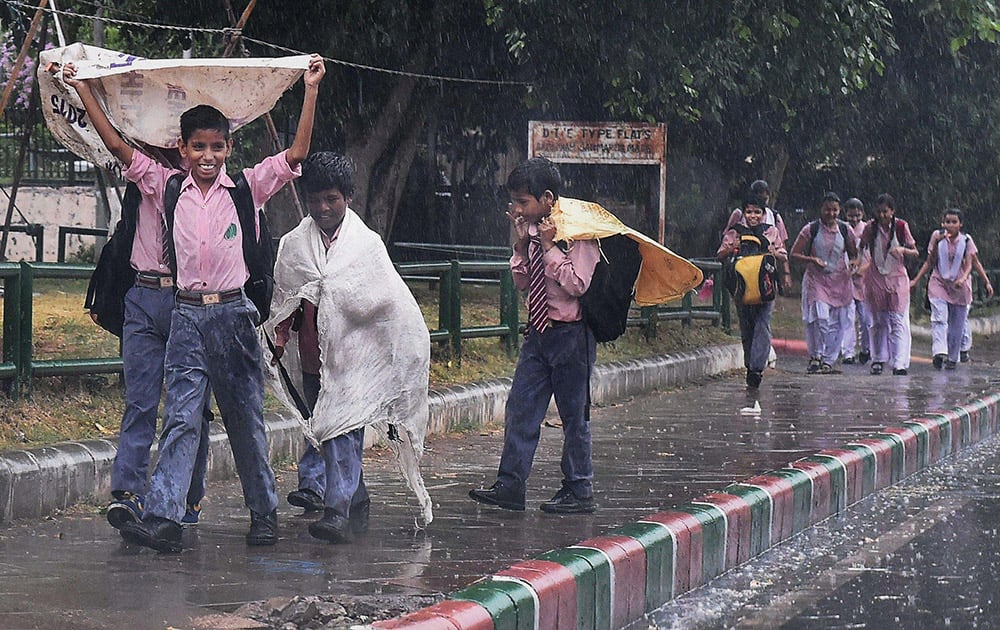 School children enjoying rain in New Delhi.