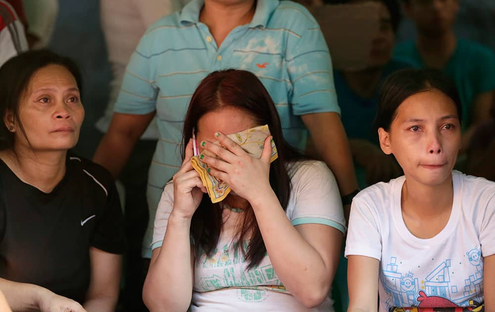 Relatives wait for news on the fate of their loved ones following a fire that gutted Kentex rubber slipper factory in Valenzuela city, a northern suburb of Manila, Philippines.